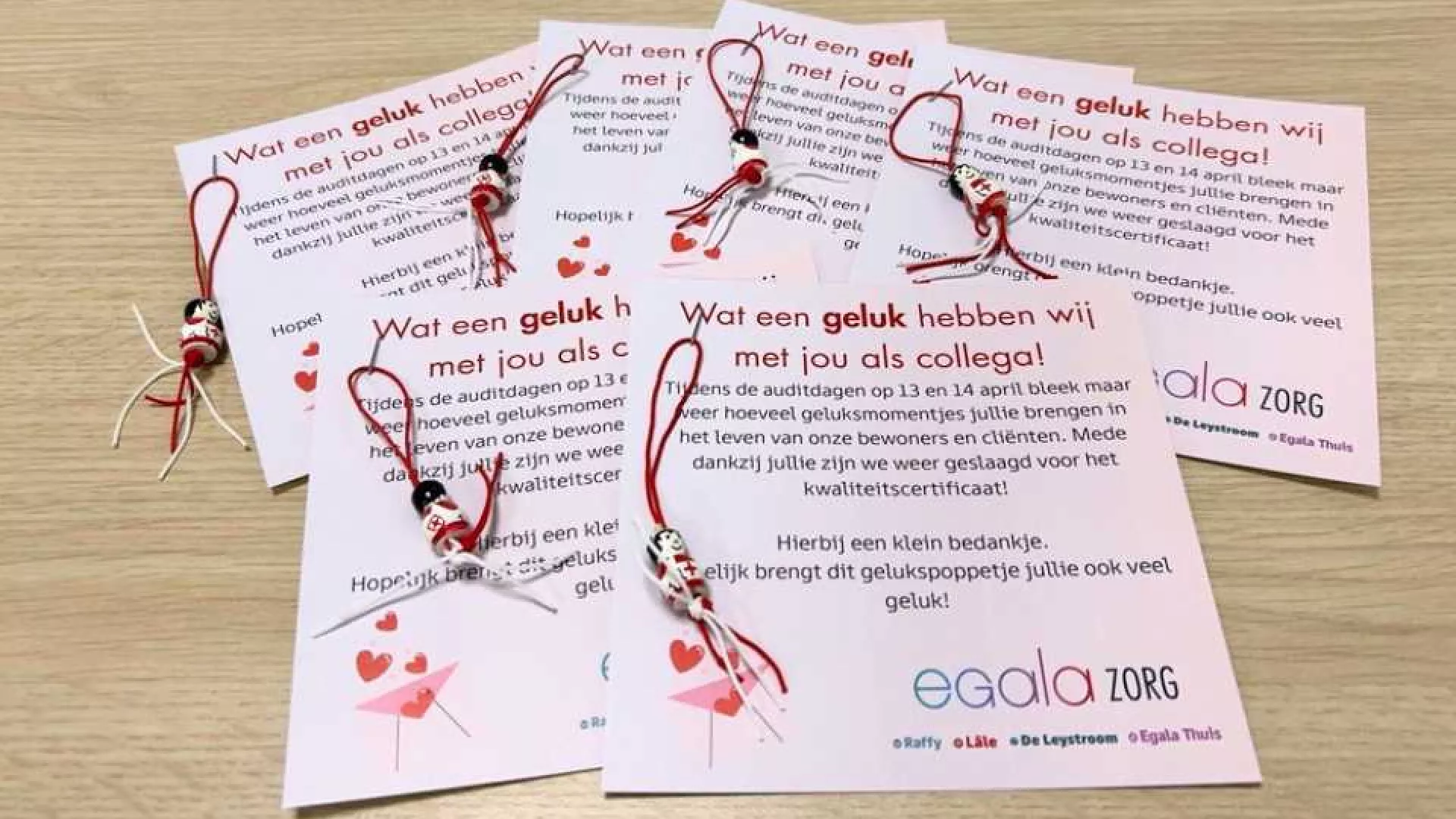 Een verzameling kaarten met rood-witte touwdecoraties en teksten van Egala Zorg.