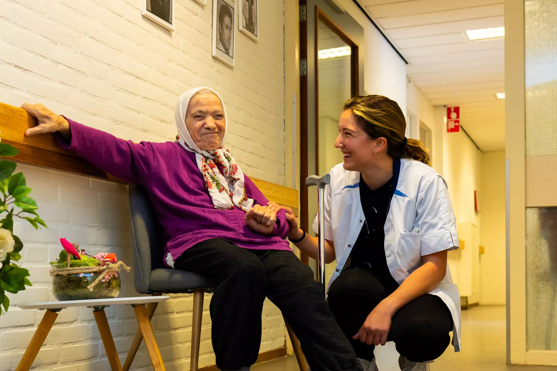 Bewoner en zorgverlener op de gang