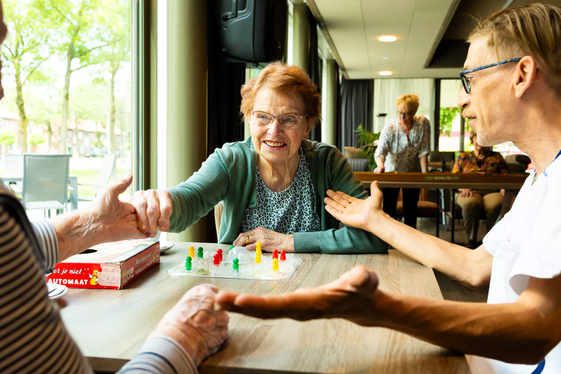 Bewoners en collega aan tafel spelletje spelen